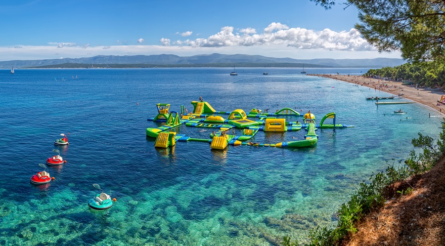 BOL, CROATIA - JULY 23, 2014: Zlatni Rat beach awarded with the Blue Flag and its water fun park that is amazing.