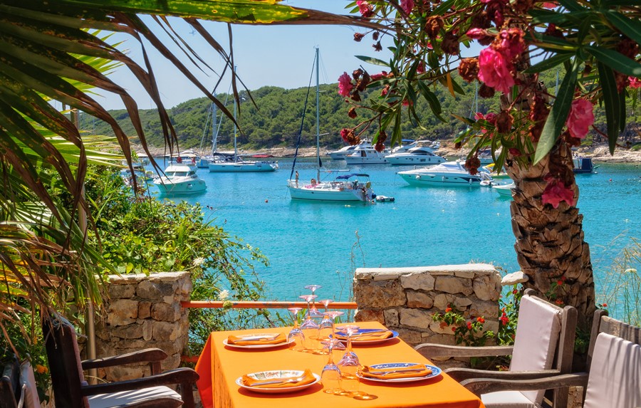 Yachts on anchor in Milne Bay photographed from the terrace of a restaurant - Hvar, Croatia