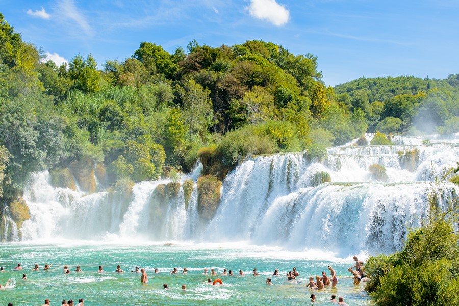 KRKA NATIONAL PARK CROATIA - AUG 26 2014: Unidentified tourists swim in the Krka River in the Krka National Park in Croatia. It is one of the National Parks in Croatia with an area of 109 square kilometers